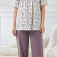 Woman wearing a floral top and purple pants