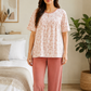 Woman wearing a pink and white patterned top and pink pants